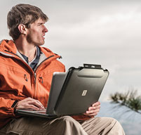 Man in an orange coat outdoors using a Peli 1070cc laptop case