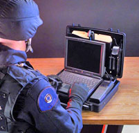 a man in miltary gear using a peli 1470 laptop case which fits laptops up to 13 inches