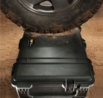 close up of peli 1690 transport case under a wheel of a vehicle