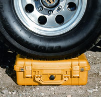 Yellow Peli Case under a wheel of a car