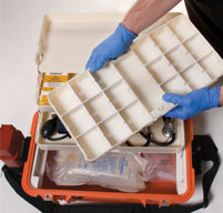 Man with blue medical gloves holding a white tray from a orange peli 1460ems case