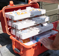 Close up of Orange Peli 1460ems case showing white trays with equipment stored inside