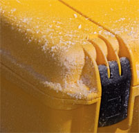 a close up of a peli storm case with snow on the lid to show its dustproof